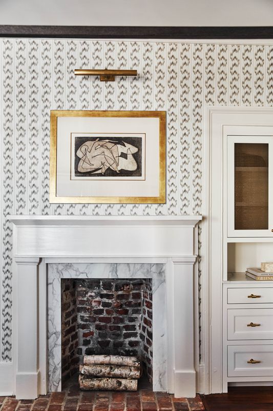 The theme is replicated in the wallpaper, drapes, and throw pillows on the oak “Whitaker” four-poster bed from Serena & Lily.