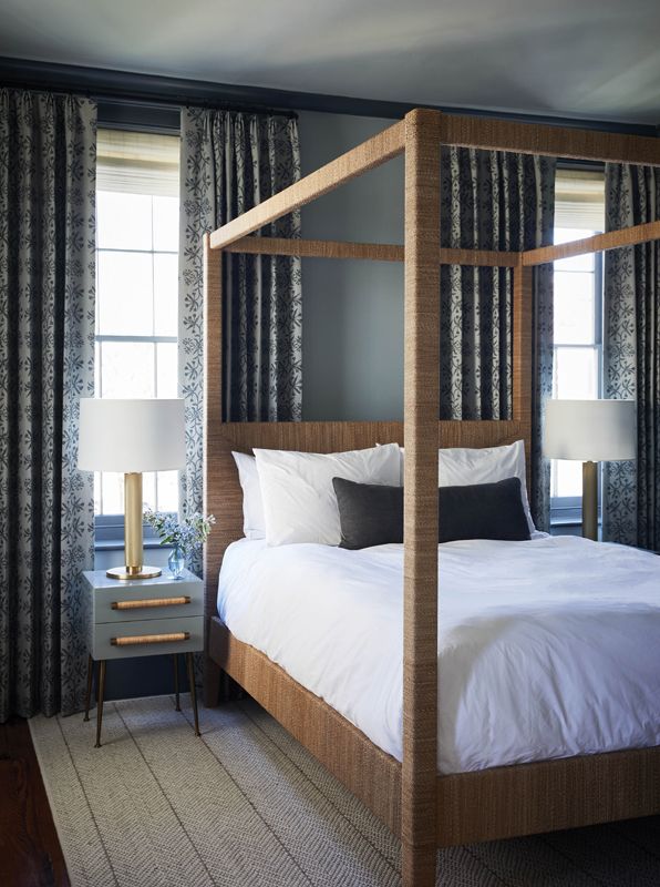 Organic Vibes: The second floor’s other bedroom belongs to one of the couple’s children. Here, a Serena & Lily “Hughes” four-poster bed, wrapped in organic lampakanay sea grass, pops against the gray floral drapes in Kerry Joyce “Best Buds” fabric and the gray walls and ceiling.