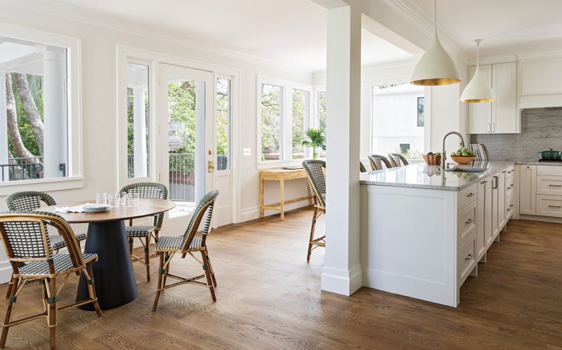 PALETTE CLEANSER: Aerin “Agnes” pendants in “plaster” illuminate a white marble countertop in the sleek and intentionally spare kitchen. Luxurious Maison Drucker cane rattan stools and chairs from Paris add a touch of style to the simple space.