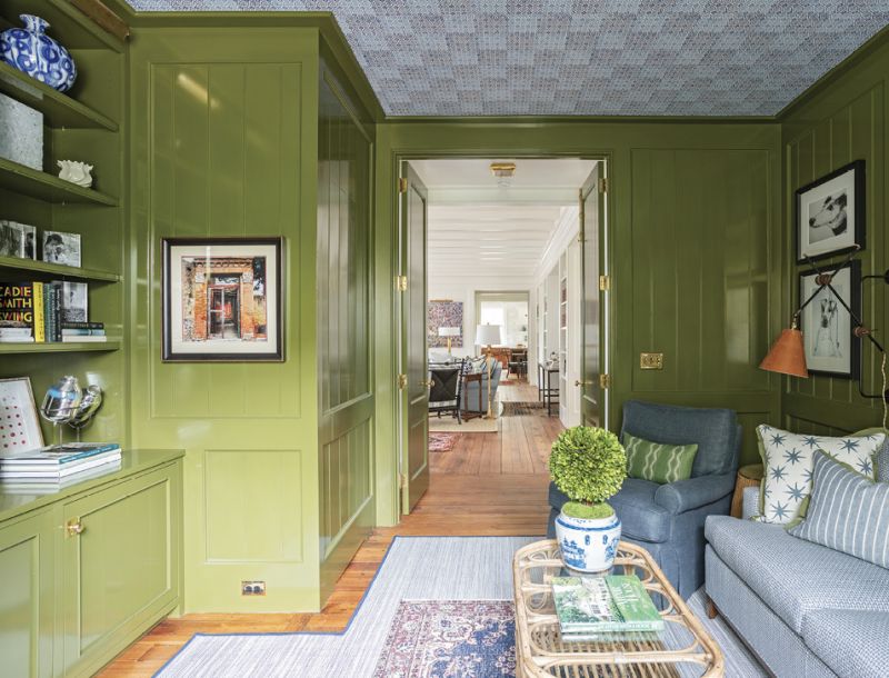 Lacquered in Farrow & Ball’s bold green “Bancha,” the adjoining media room is a cozy place to watch a movie or curl up with a good book. Peter Fasano wallpaper on the ceiling gives the feel of mosaic tile.