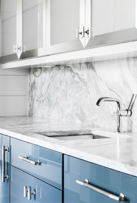 “Fantasy Brown” marble pops against glossy cabinets in the wet bar/guest corridor