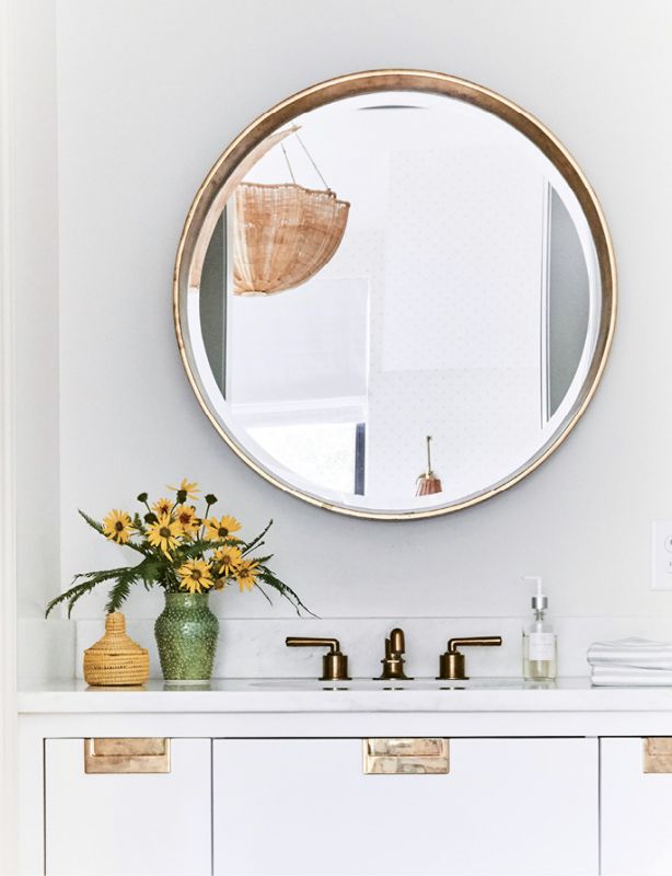 Brass in the bath pops against soft gray walls painted in Farrow & Ball’s “Slipper Satin.”