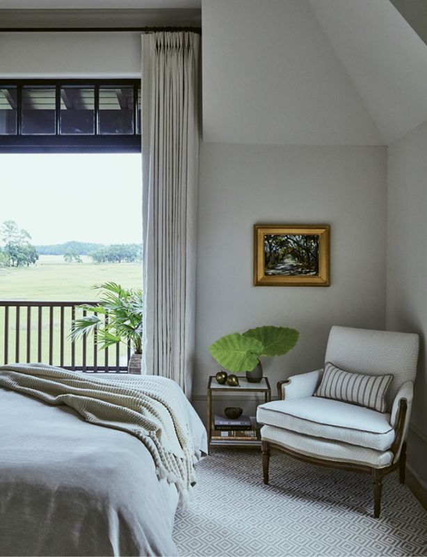In the third bedroom, an antique chair, bought at an auction and upholstered in a Schumacher fabric, sits on a rug from Stark Carpet.