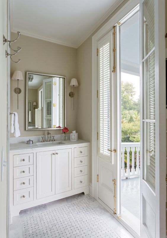 SOAK IN THE VIEW: The downsized master bathroom prioritized access to the piazza over soaking space (there’s no tub), keeping clean lines along with classic marble touches thanks to “Melissa Wall” sconces by Urban Electric and a Calacatta basketweave tile floor.