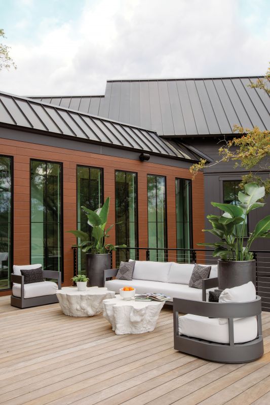 On Deck: Fiber cement siding that mimics the look of real wood with none of the maintenance issues brings warmth to the outdoor seating area, where Serena & Lily “Boonville” coffee tables cast from real tree roots continue the organic look.