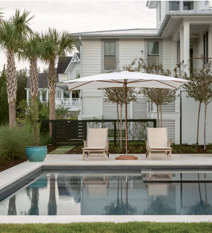 Closer to the home, teak lounge chairs from Kingsley Bate’s St. Tropez collection are sheltered by a white canvas Tucci umbrella.