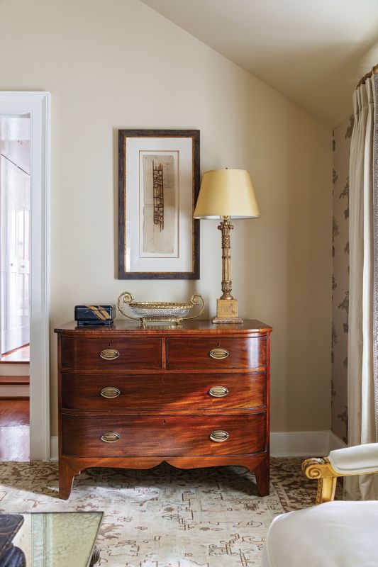 Midas Touch: The Griffins’ antique chest pairs with a French neoclassical Baccarat bowl from Chairish and an Italian gilt-wood lamp from The Antique and Artisan Gallery, topped with a custom lampshade.