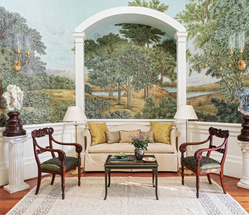 ANTIQUE ALLURE: Ralph filled one area of the rotunda with a custom sofa surrounded by two Regency armchairs and a coffee table from Terrace Oaks antiques. Two pillows covered in a gold Fortuny fabric provide a pop of color while two neoclassical floor lamps from Well Furnished and a pair of double wall sconces from Urban Archaeology in the Federalist style add light to the previously dark room.