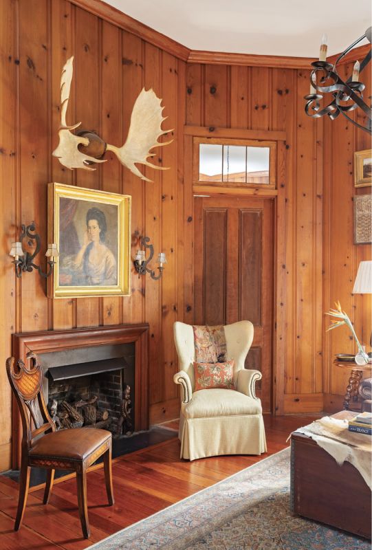 Warming Trend: The wood-paneled den was completed in the 1950s by then-owner author Paul Hyde Bonner for his study. The pine comes from a mill in Summerville that’s still operational. Ralph sourced a few accessories to complement the warm room, including a gold-leaf-framed portrait from 17 South Antiques and a vintage chair from Antiques of South Windermere. She livened up the space with fun fabric from Rogers & Goffigon and Cindy Barganier Textiles for the sofa pillows.