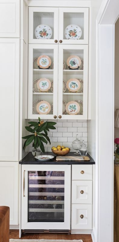 Kitchen Confidence: An antique etched bell lantern hangs above a restored Winn Dixie butcher-block table (opposite), which lends old-world charm and additional work space. Classic brass hardware gives the new cabinetry painted in Sherwin Williams’s “Aunt Betty’s China” an antique touch.
