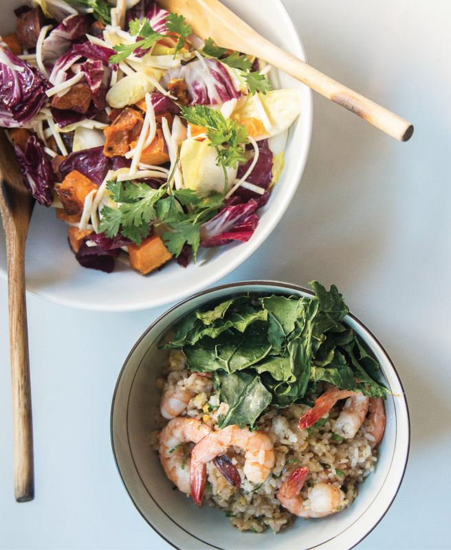 Bowls of the celery root and sweet potato salad and shrimp fried rice; Walker and Li top the rice with crispy baked kale, a healthier alternative to deep- fried garnishes.
