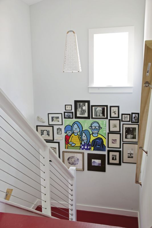 A painting by artist Marius Valdes adds color to a grouping of black-and-white family photos.