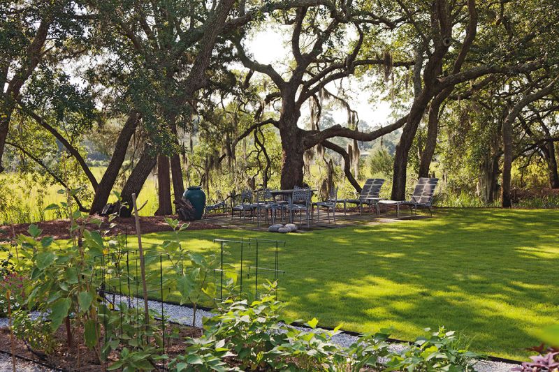 The space is outfitted simply with teak furnishings and woven chairs, so as not to distract from views of the gorgeous wetlands and live oaks
