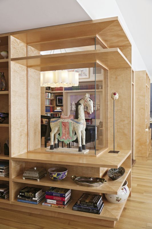 Built-in shelves with custom display cases showcase artwork while opening up the original rooms’ choppy layout.