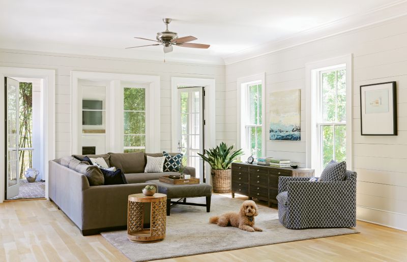 Lap & Light: Shiplap walls throughout the main living and dining rooms give a “buttoned-up” feel to the casual décor, says Lenox. Loads of natural light energize the airy rooms, and a calming palette of soft greys adds a sophisticated feel.