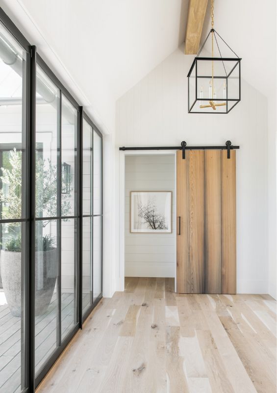 Feature & Function: Designed to draw the eye to the landscape beyond its floor-to-ceiling windows, the entryway’s white oak flooring, cypress barn door, and wooden beam are accented by steel and glass, including an Urban Electric light fixture and custom door hardware.