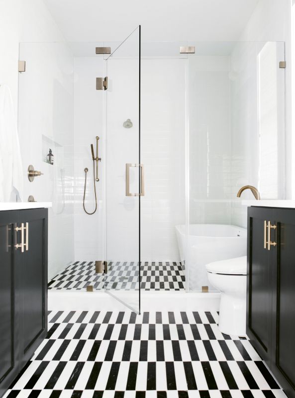 CLEAN & SERENE: The master suite rivals boutique hotels for its comfort and style. A space-saving “wet room” configuration in the bath fits a walk-in shower and soaking tub, while glistening white-tile walls, cabinets covered in Benjamin Moore’s “Black Beauty,” and a custom-cut marble tile floor add drama.