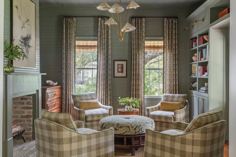 In the library, soft green walls (in Farrow & Ball “Treron”) provide a cozy backdrop for four Highland House chairs covered in a buffalo check fabric from Fabricut.