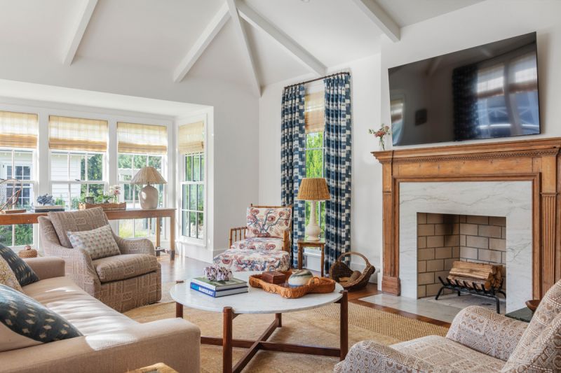 Vintage pieces—such as a rattan game table, a 19th-century English pine mantel, and a long draper’s table—mesh with contemporary, family-friendly sofas from Verellen, a custom coffee table by Benjamin Paul Studio, and a whimsical abstract painting by Charlotte, North Carolina-based artist Ted Lee.
