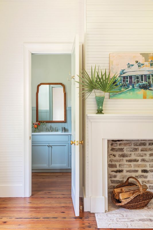 On the opposite side of the central hall, the girls’ playroom features the home’s other original fireplace, highlighted with a white mantel. The room, with its en-suite bath’s beadboard painted in Farrow & Ball “Light Blue,” can double as a guest room.