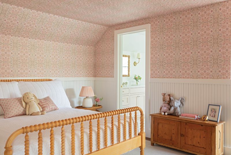 The second floor, formerly a full apartment, has been reworked to accommodate two spacious bedrooms, one for the couple’s eldest daughter and the second as a nursery for their youngest. A playful Helen Prior wallpaper from Fritz Porter rises above restored beadboard in the first room, where a vintage wooden chest pairs with a Jenny Lind bed from Crate & Barrel.