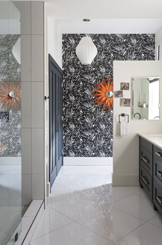 Space Saver: The master bath required significant reconfiguring—gone are the bathtub, window, and door to the piazza—to accommodate a closet, laundry room, and walk-in shower. An orange mirror provides a pop of color on the graphic palm frond wallpaper from Serena & Lily.