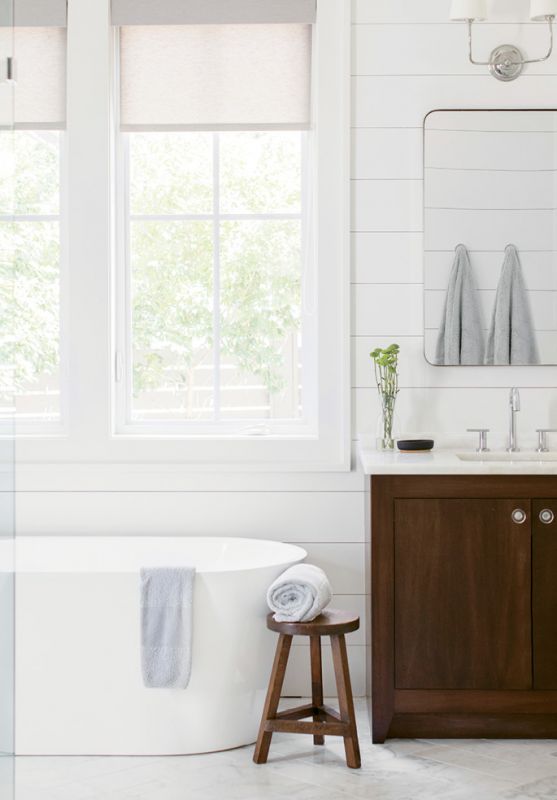 R&R: In the master bath, a large soaking tub overlooking the backyard separates his-and-her marble-topped vanities. An expansive shower with frameless glass and penny marble tile completes the retreat.