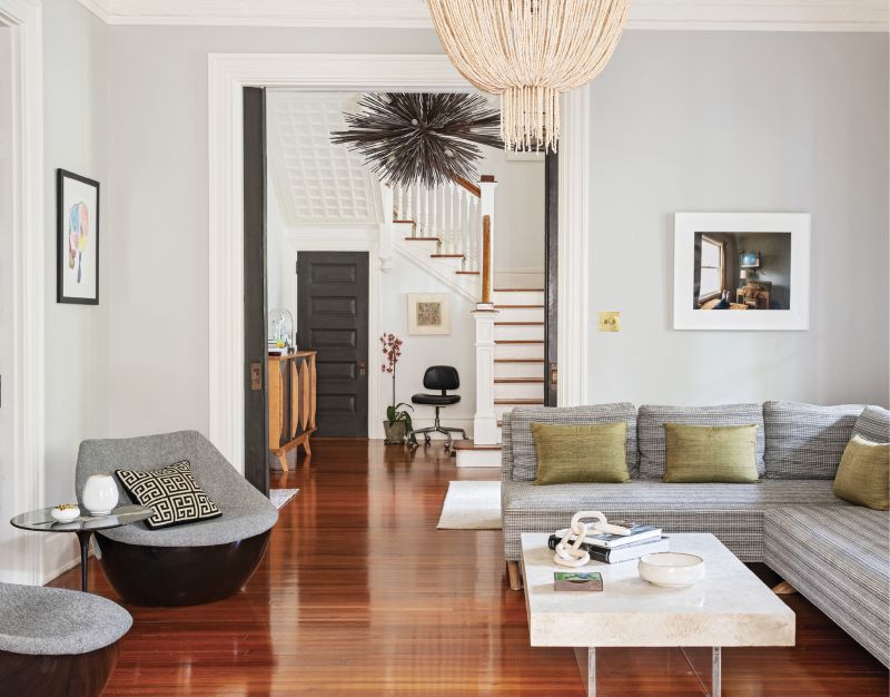 Mixed-Century Modern: The meticulous craftsmanship of the house provided the ideal canvas for Sarah to combine modern and antique furnishings. In the living room, orbital chairs from Modus Furniture face a Fernando Santangelo custom sofa. The coffee table, a solid slab of coral and concrete floating on a Lucite base, is a unique focal point.