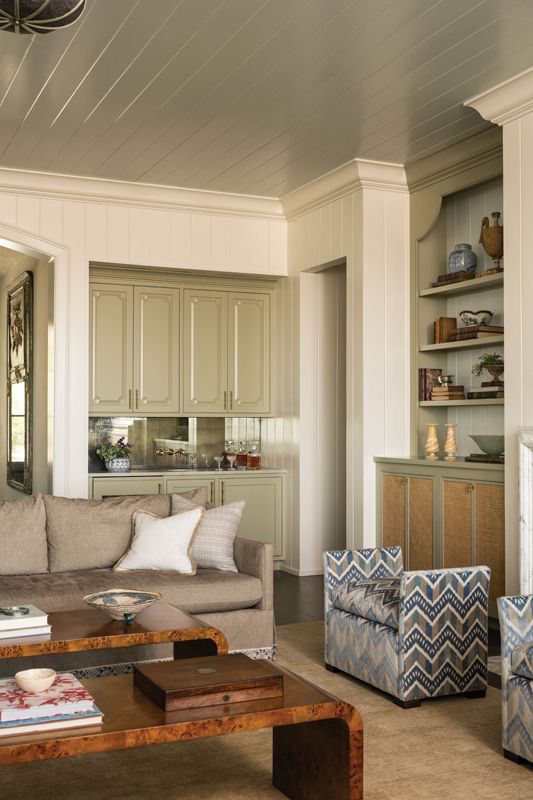 A built-in wet bar and cabinets surrounding the fireplace were inspired by late 20th-century Chippendale cabinets and designed to feel timeless with a subtle sense of whimsy.
