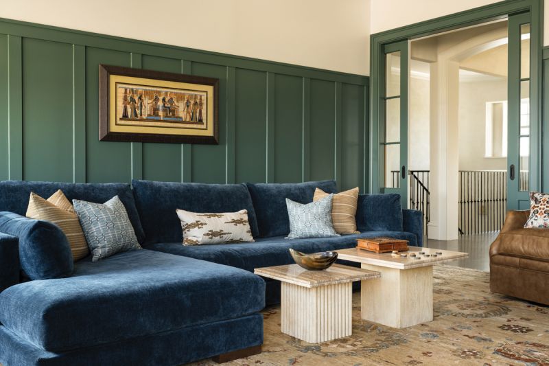 A large blue sectional from Younger & Company provides plenty of seating, and a wet bar leading to a rooftop balcony facilitates entertaining.