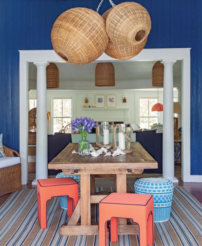 Woven Whimsy: A custom-designed cluster of wicker pendant lights from Serena & Lily dominates the entryway/dining room. A vintage cabinet from Indigo Market provides storage space as well as a showcase for two striking lamps from Chairish and a mirror from Candelabra.
