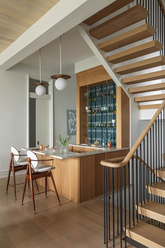 Overgaard & Dyrman “Circle”  stools nestle up to a reeded white oak bar alongside the floating white oak staircase.