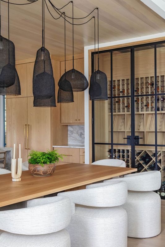 The wine room off the dining area blends in with the white oak kitchen cabinetry.