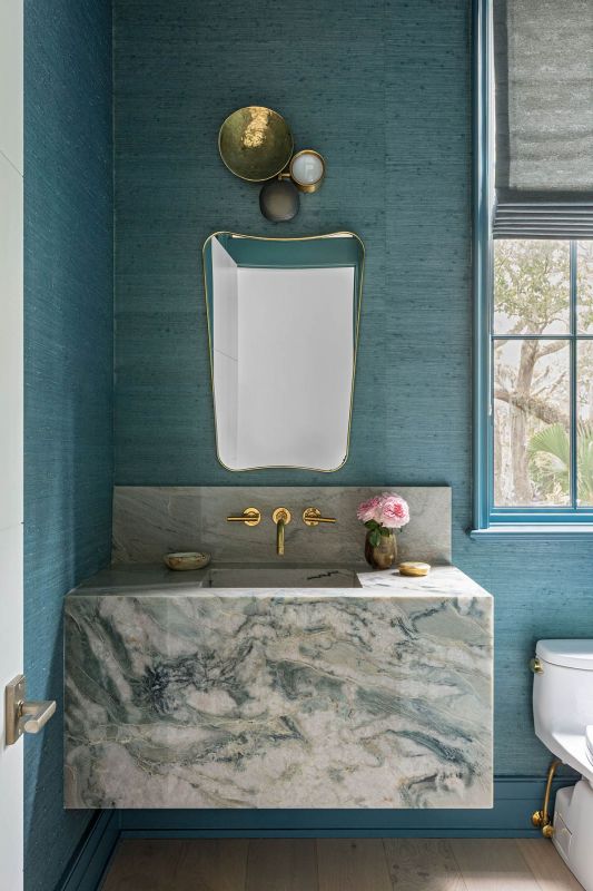 A marble sink on blue grasscloth
