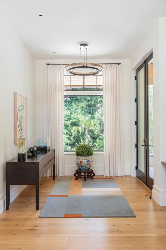 A Dale Chihuly glass sculpture and signed print in the foyer inspired the selection of this geometric “Landscape” rug from Design Within Reach.