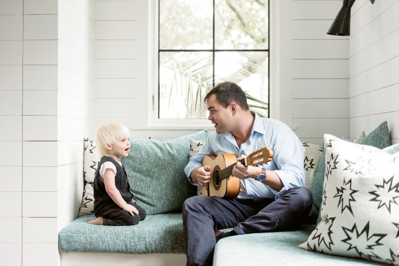Ted serenades Fox in the nursery amongst pillows upholstered in playful comic book-inspired fabric.