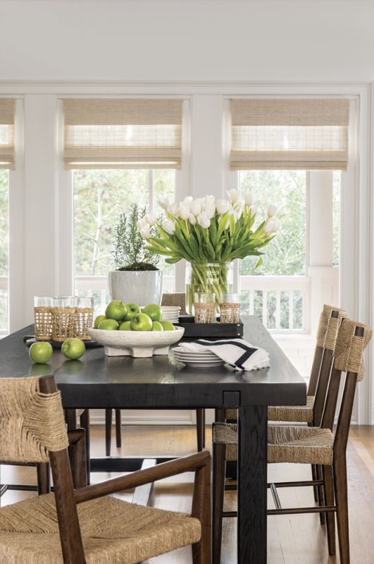 Just beyond, the dining room hosts a large Restoration Hardware table surrounded by Serena & Lily woven arm and side chairs.