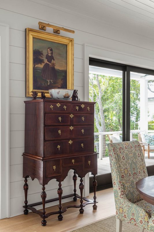 A William and Mary highboy dating to the late 1600s, passed down from Jean’s father, anchors a quiet dining corner beneath a moody oil painting inherited from her mother’s collection.