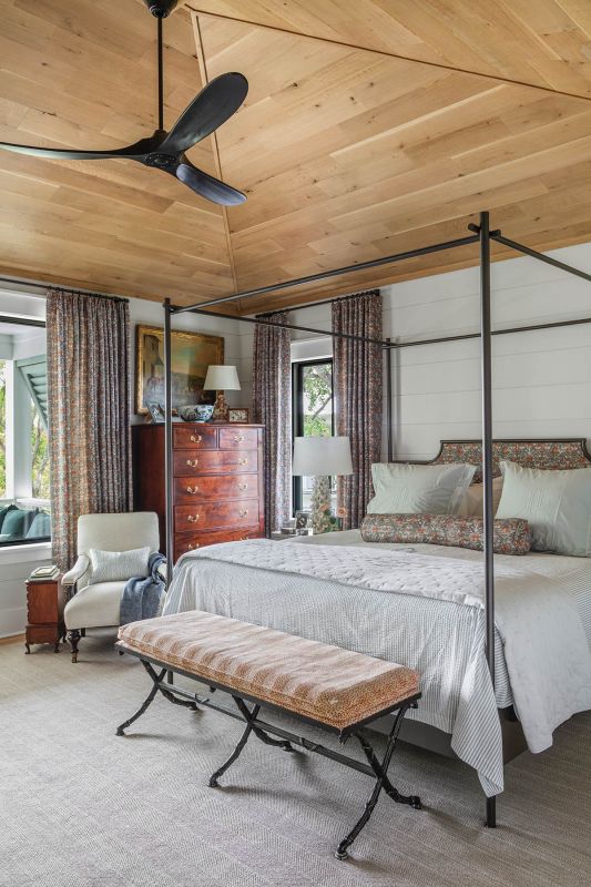 The custom Charleston Forge iron bed is upholstered in Zak + Fox “Khotan” in “Rubia,” repurposed from the clients’ Old Village den curtains. This is one of the few entirely new statement pieces in the house. “I fell in love with a bed I saw in a magazine,” Jean says.