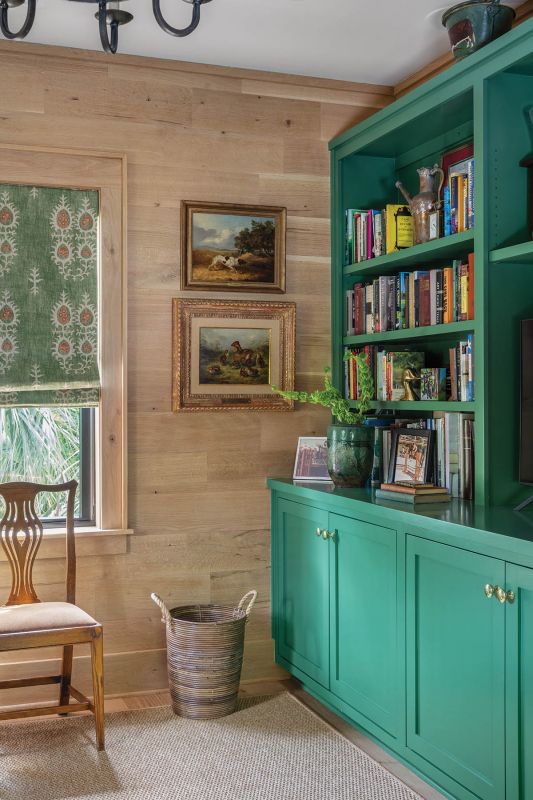 Upstairs, Jean’s office is wrapped in warm, white oak that allows the large, built-in bookcase painted in a bold Benjamin Moore “Balsam 567” green to pop.