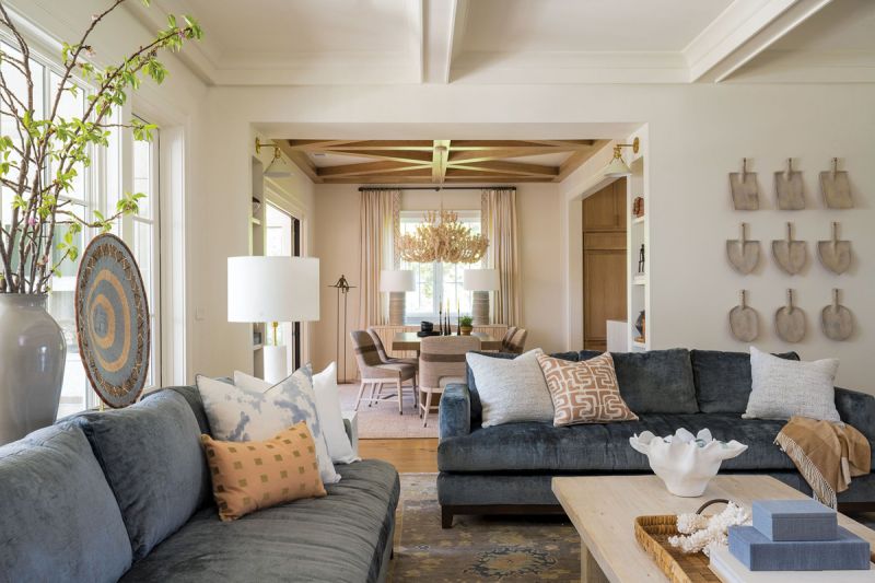 offered ceiling in the living room continues the open-yet-separate feel of the downstairs. Deep blue sofas from the couple’s home in Asheville provide a pop of color against the walls painted in Benjamin Moore “White Dove.”