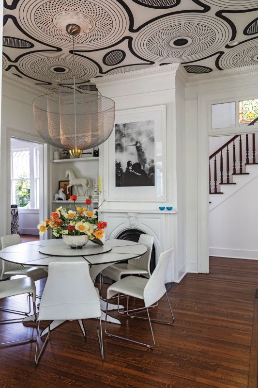 Designer Ghislaine Viñas’s “ShweShwe” wallpaper elevates graphic action on the high ceilings and meshes with the 19th-century egg-and-dart molding and ceiling medallion. A vintage Dirk Wynants “Arthur” dining table echoes the circular designs, and a Moooi “Meshmatics” light fixture reflects the Mendezes’ love of Dutch design.