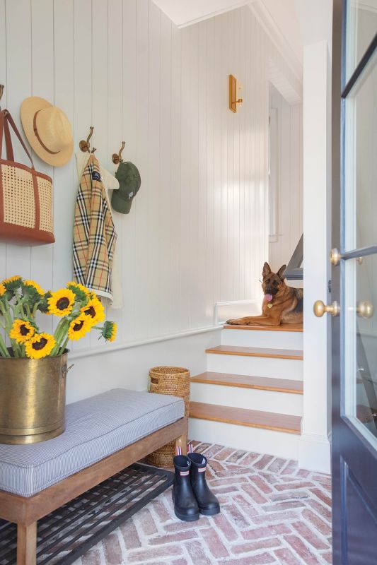 The mudroom entrance features a herringbone brick floor and shiplap paneling.
