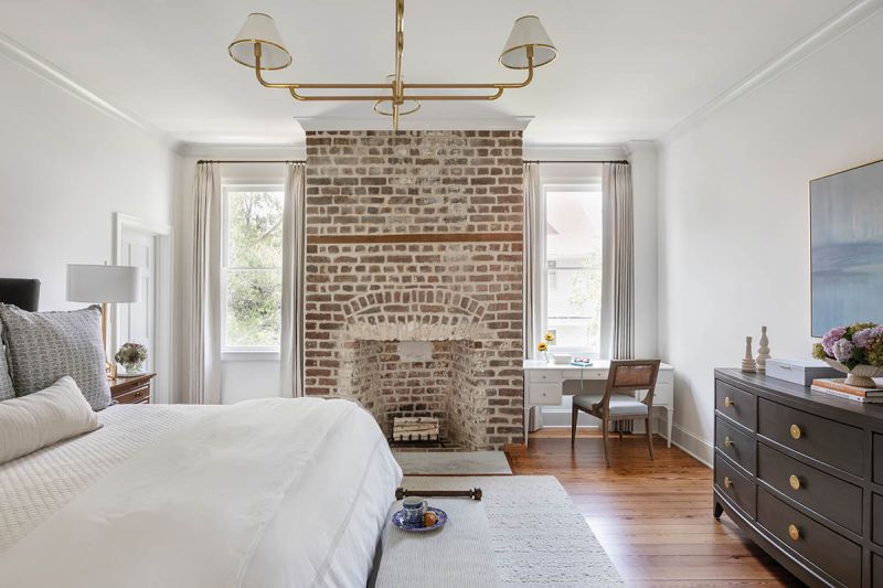 In the primary bedroom, a linen-dressed Gabby bed rests atop a cream Jaipur Living rug. The Phillips Scott “Bentley” chest and headboard, both in charcoal, offer contrast.
