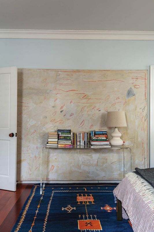 A deep blue Moroccan flat-weave rug frames a second abstract piece by Doug Higgins, adding a touch of drama.