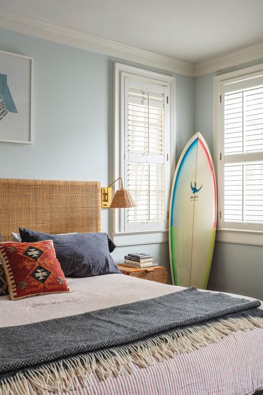 Cheerfully Chillaxed: Upstairs, the primary suite embraces a modern, casual vibe. A Serena & Lily rattan wicker bedroom set stands out against the soft Farrow & Ball “Kakelugn” blue walls, offering a peek into Reeves’s more relaxed side.