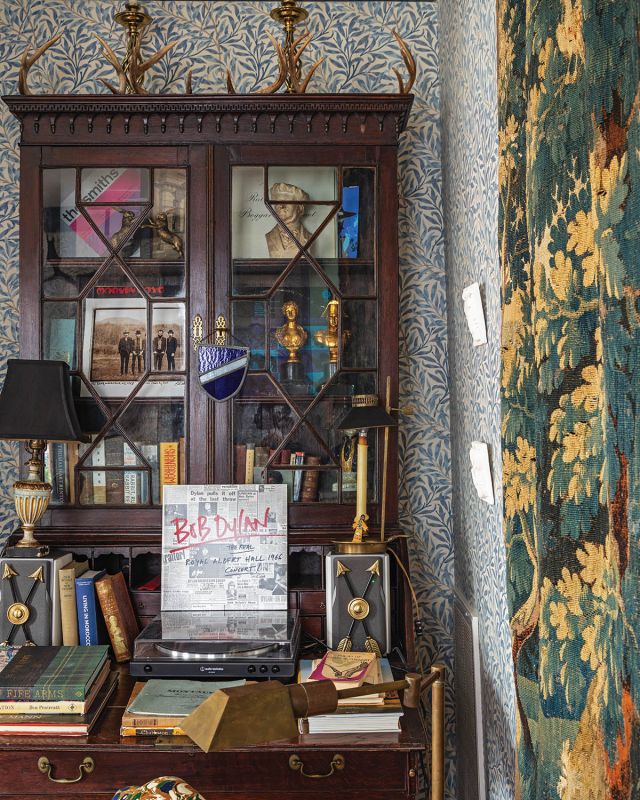 A Rich Tapestry: An English oak secretary that Reeves purchased from Alex Raskin Antiques in Savannah houses his record player and vinyl collection. A 18th-century Aubusson Verdure tapestry reinforces the room’s blue and green color palette.