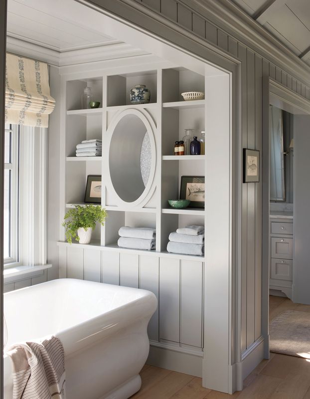 The Hydro Systems bathtub is encased in a large cubby, where a window allows for forest views and ample shelving ensures everything is in easy reach.
