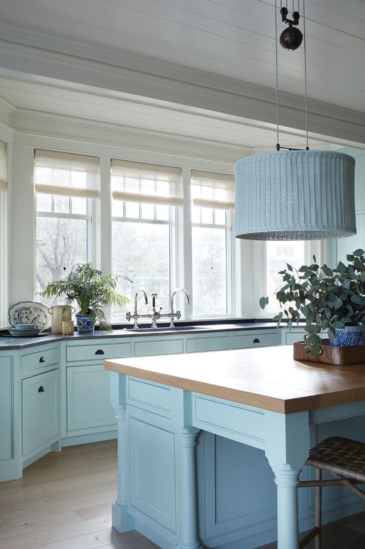 Cool Storage: The spacious butler’s pantry continues the aqua theme with a wall of shelving for the homeowner’s collection of vases.