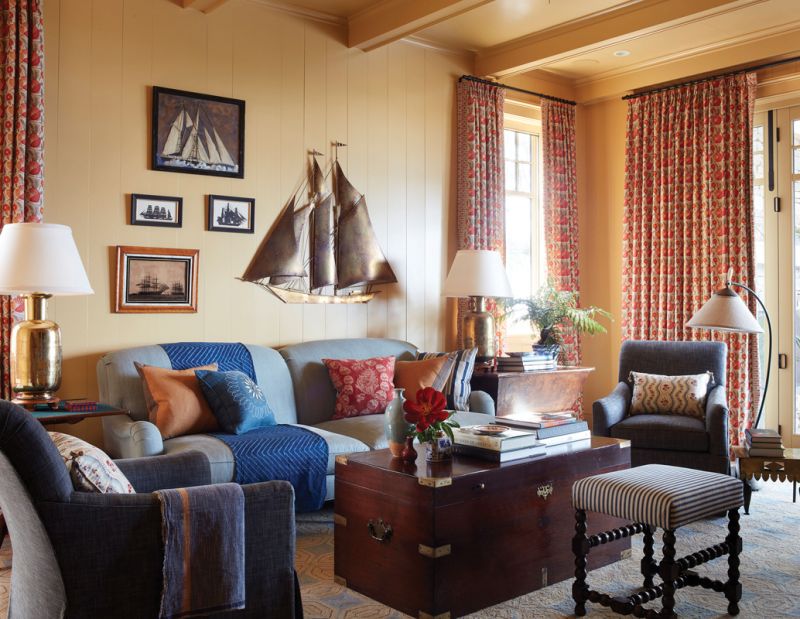 Get Cozy: The den’s warm palette and soft furnishings provide contrast with the rest of the open and bright downstairs living space. Walls painted in “Octagon Yellow” by Farrow & Ball set the tone, where an overstuffed sofa from TCS Designs in North Carolina and Lee Jofa swivel chairs surround an antique trunk from Parc Monceau and chunky brass lamps from Fritz Porter shine.